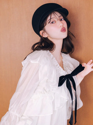 Close-up of the SNIDEL ribbon frill tunic on a model, showing the ruffled neckline, sheer fabric and black velvet bow.