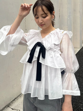 Sleeve detail of the SNIDEL ivory ribbon frill tunic on a model, showing sheer fabric, gathered sleeves and flared cuffs.