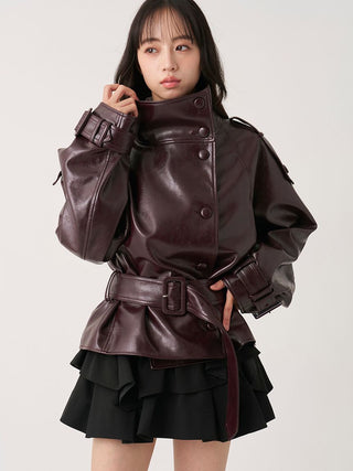 Model wearing the brown SNIDEL Stand Collar Belted Jacket fastened over a black ruffled mini skirt.

