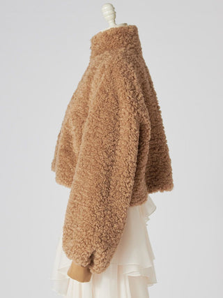 A tan teddy fleece cropped jacket displayed on a cream-colored mannequin dress form against a light gray studio background.