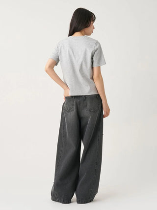 A woman shown from the back wearing a light gray short-sleeve t-shirt and dark gray wide-leg denim jeans, photographed against a plain light gray studio background.