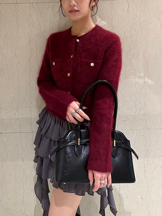 Model wearing the gray SNIDEL Twist Frill Mini Skort with a burgundy cardigan and carrying a black handbag.