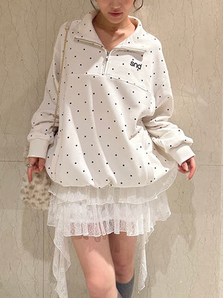 Front view of the white SNIDEL Twist Frill Mini Skort styled with a polka-dot sweatshirt and patterned shoulder bag.