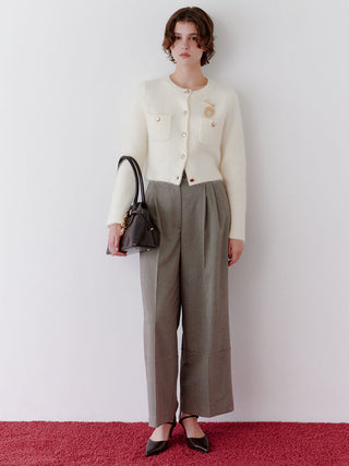 Model wearing the checked SNIDEL Belted Tuck Pants with an ivory cardigan, dark handbag and pointed-toe heels.