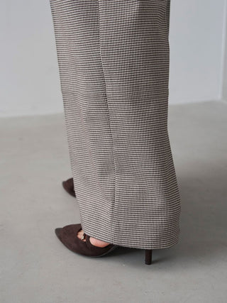 Close-up of the checked SNIDEL Belted Tuck Pants' wide hem and pressed crease, worn with dark heels.