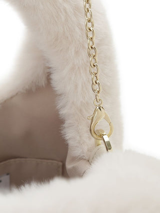 Close-up of a fluffy cream faux-fur bag with a beige fabric lining and a gold-tone chain strap clasp.