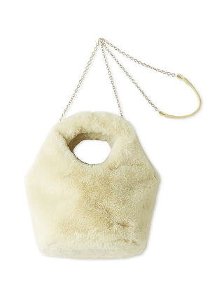 A cream-colored faux fur handbag with a hexagonal shape, featuring a circular cutout handle and a gold-tone chain strap with a curved accent.
