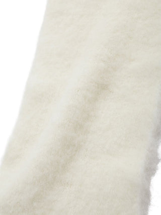 A close-up of a soft, fluffy faux fur or sheepskin material in a warm off-white or cream color, showing its plush texture against a plain white background.
