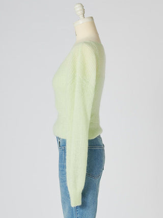 A pale mint green knit sweater displayed on a mannequin torso with blue jeans against a light gray studio background.
