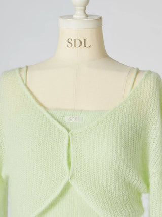 A pale mint green knit cardigan sweater displayed on a cream-colored mannequin torso. The cardigan features a soft, fuzzy texture and a draped front design with a square neckline.