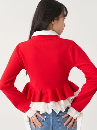 A woman shown from the back wearing a bright red long-sleeve cropped jacket with a white ruffled collar and hem, paired with blue jeans, against a plain light gray studio background.
