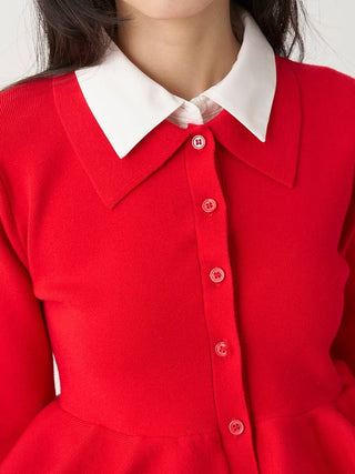A close-up of a bright red knit dress with a contrasting white pointed collar and matching red buttons down the front.